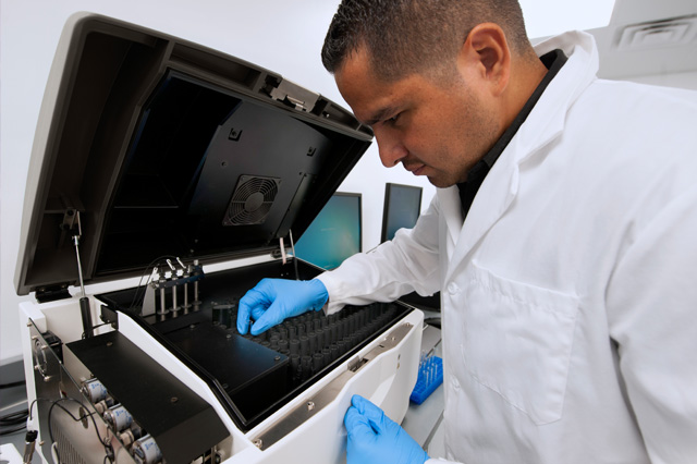 A quality control microbiology lab analyst or technician uses a Celsis rapid microbiological detection system to test samples for microbial contamination.